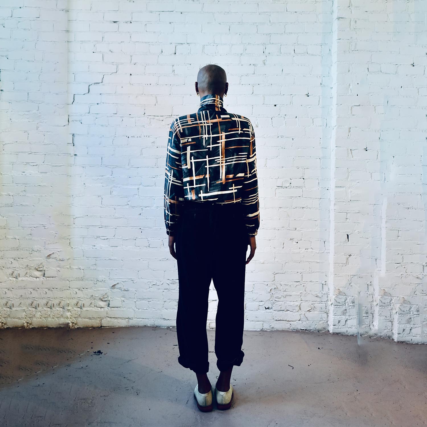 Model wearing a vintage silk bomber jacket with multi-square pattern.