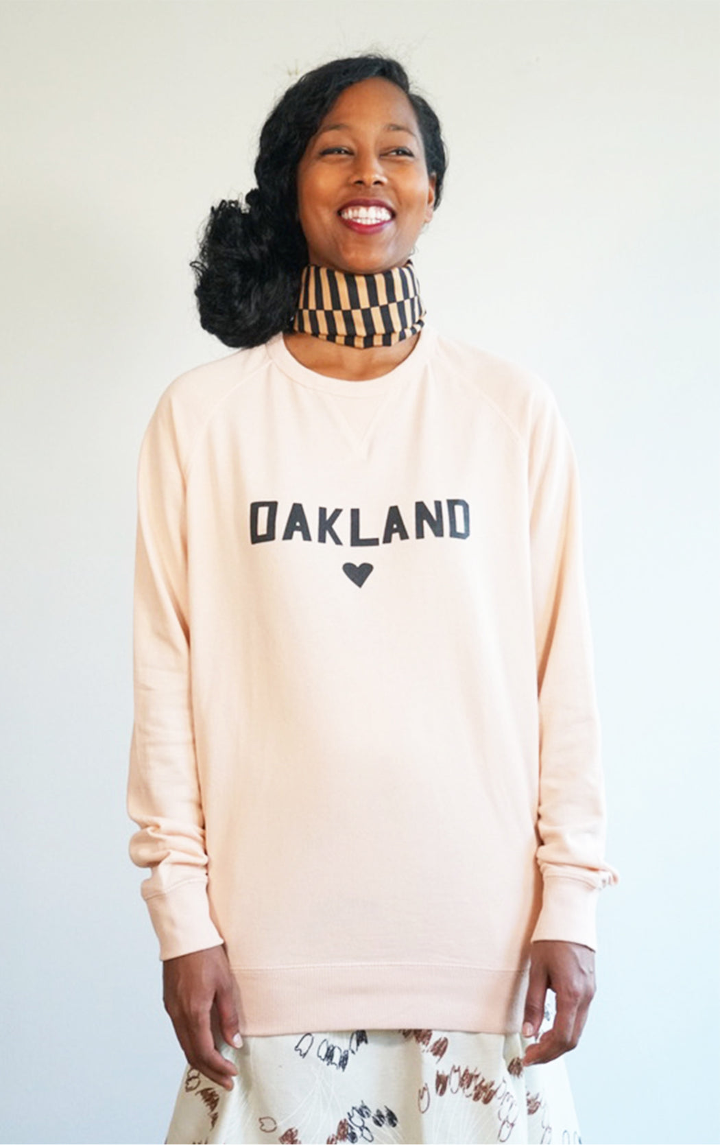 pink super soft love oakland sweatshirt in a cool crew neck style made in a soft cotton blend with love oakland heart graphic on front 
